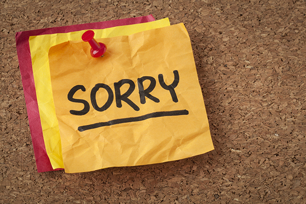 Sorry written on crumpled post it note
