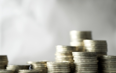 Close up of pile of coins on grey background