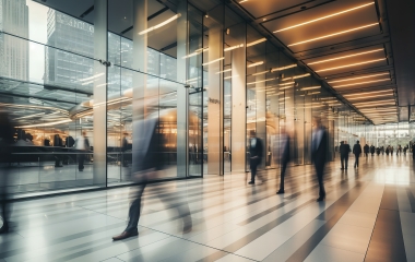 Long exposure shot of crowd of business people walking in bright office lobby fast moving with blurry