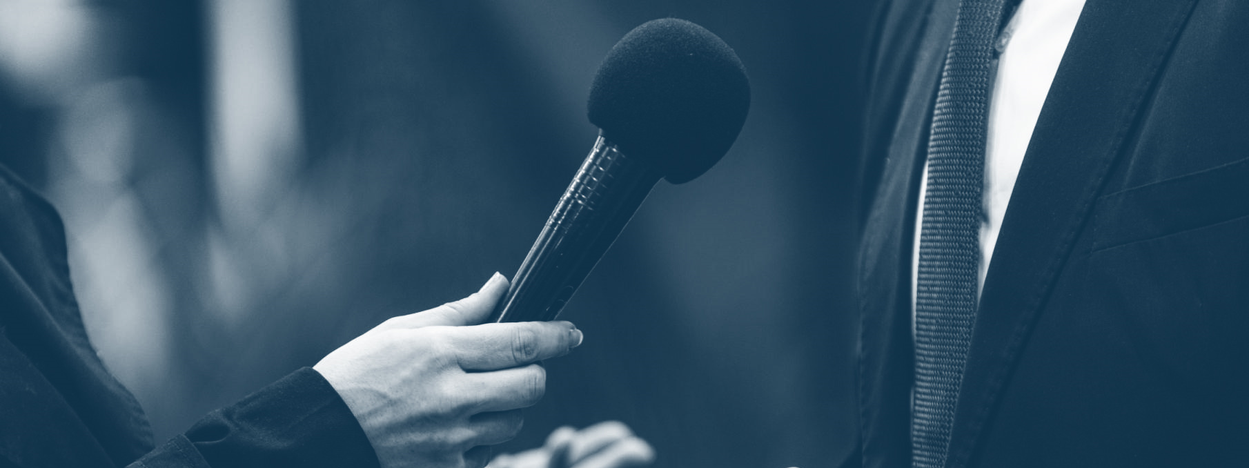 microphone being held up to person in suit