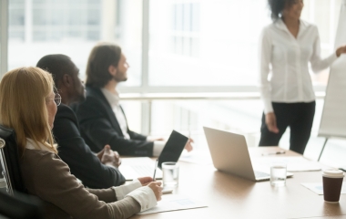 Person presenting to 3 people in a boardroom
