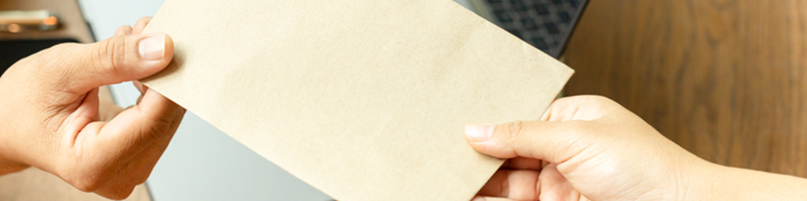 Two people exchanging an envelope