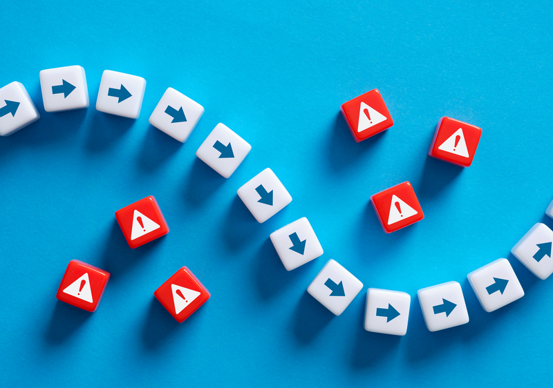 Dice with arrow pointing through dice with caution symbols