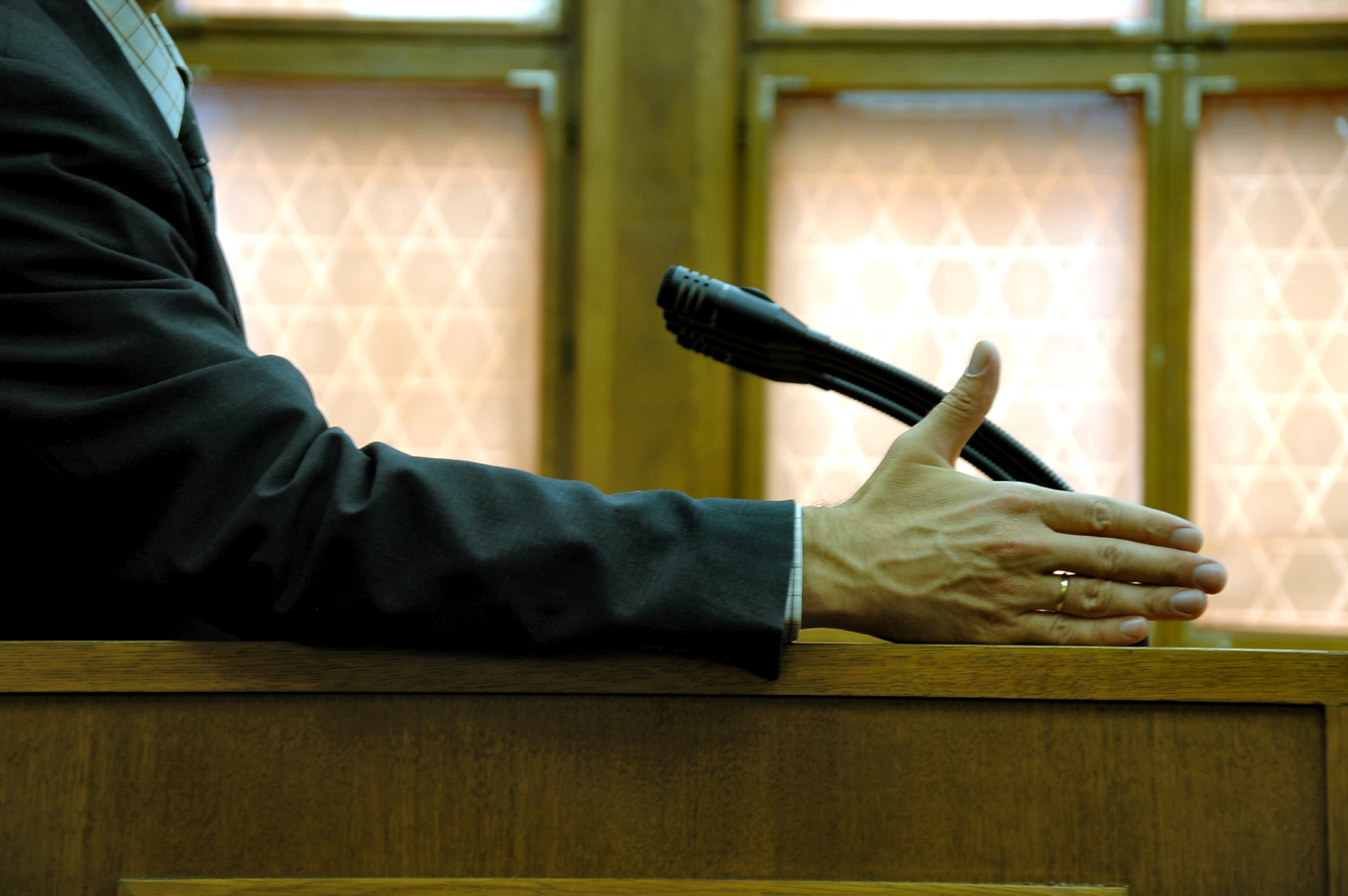 Man on a stand in the courtroom with his hand out