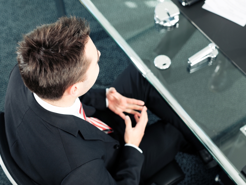 Businessman in business attire with brown hair sat during a meeting