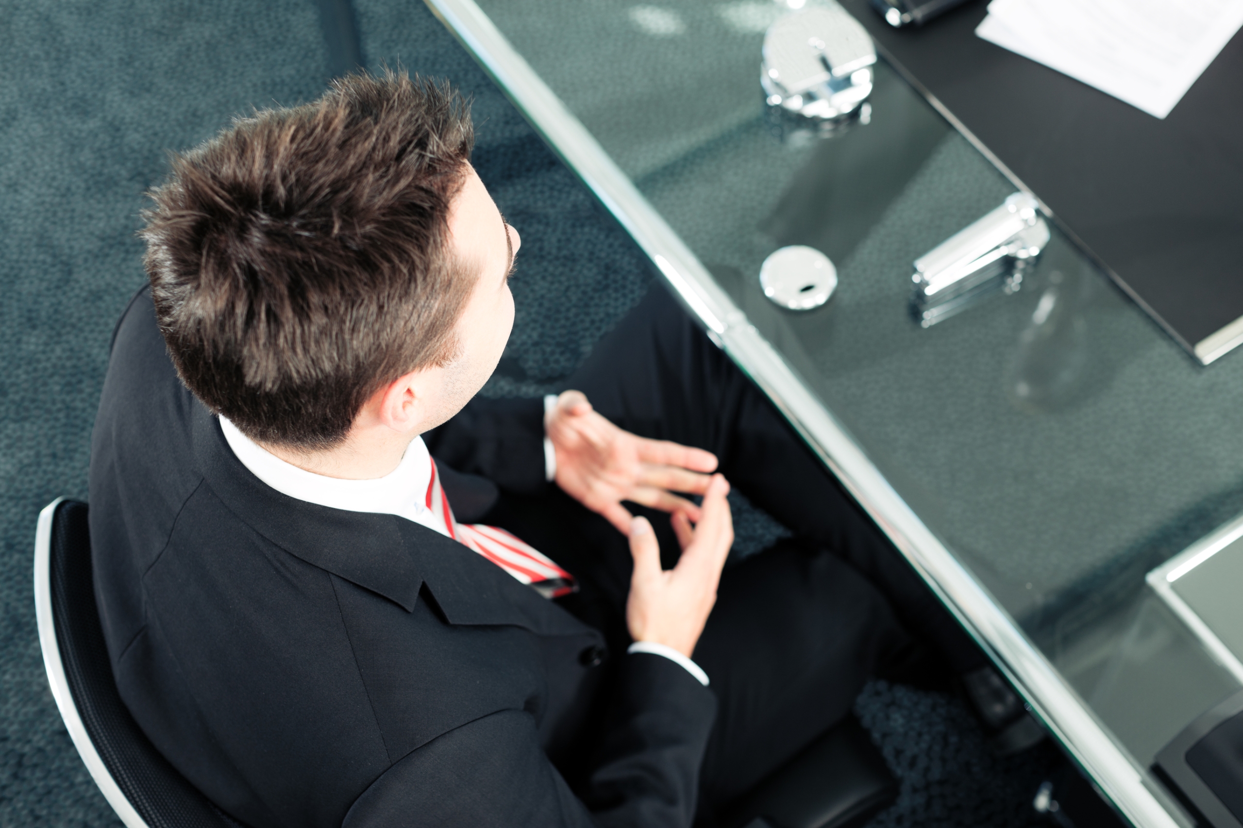 Businessman in business attire with brown hair sat during a meeting