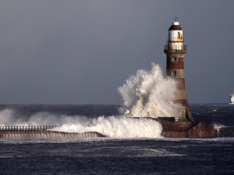 A wave crashing against a lighthouse